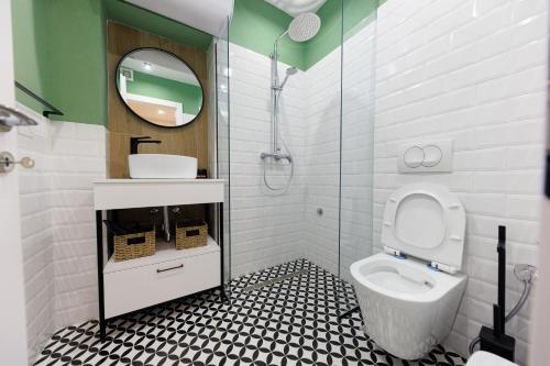 a bathroom with a toilet and a sink and a mirror at Syncron Centre Skyline Rooftop Tirana Apartments in Tirana