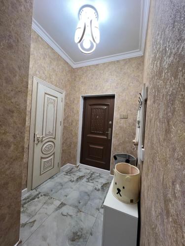 a room with a hallway with a door and a sink at Sweet Apartment in Narimanov in Baku