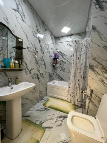 a bathroom with a sink and a toilet and a tub at Sweet Apartment in Narimanov in Baku