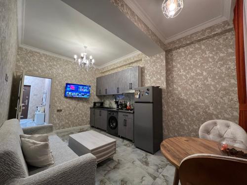 a kitchen and living room with a refrigerator and a table at Sweet Apartment in Narimanov in Baku