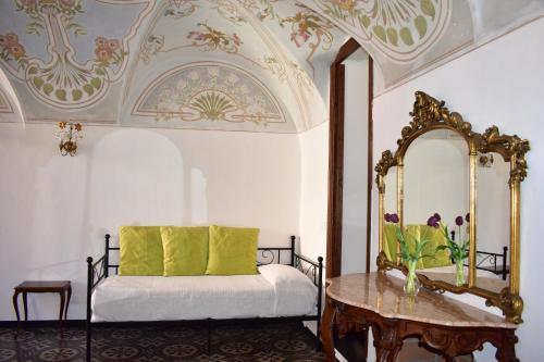 a bedroom with a bed with a mirror and a table at Appartamento magico nel centro del borgo L'ancora. in Laigueglia