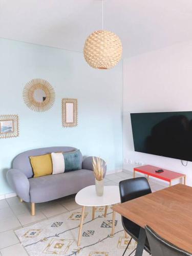 a living room with a couch and a table at Appartement T3 chic et cosy in Cayenne