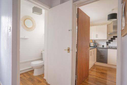 a small bathroom with a toilet and a sink at Raymond James Accommodation, sleeps up to 7, free parking, full amenities and garden in Peterborough