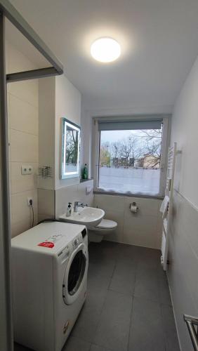 a bathroom with a washing machine and a sink at Zimmervermietung38 - Wild 3 in Salzgitter