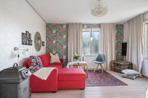 a living room with a red couch and a window at The Solhem Cabin in Strömstad
