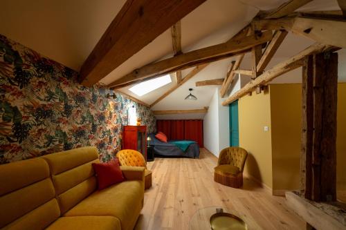 salon z kanapą i łóżkiem w obiekcie Le Clos Saint-Jean - Chambre d'hôte Scarlett w mieście Saint-Jean-de-Thurac