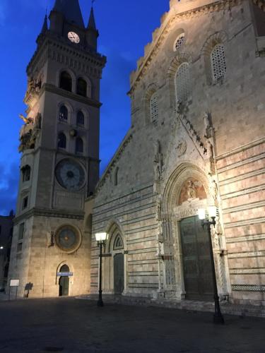 a large building with a clock tower on it at Casa Cicerone in Messina