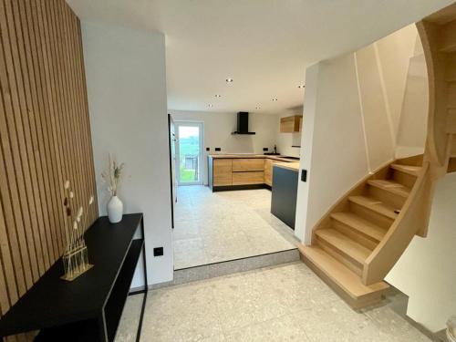 uma sala de estar com uma escada e uma cozinha em Gite de Clermont em Thimister