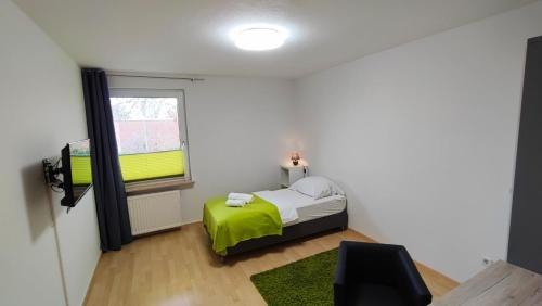 a bedroom with a bed with a green blanket at Zimmervermietung38 - Nebel in Salzgitter