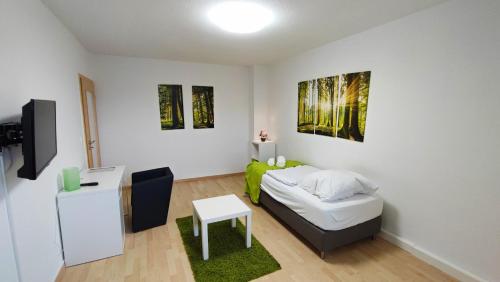 a bedroom with a bed and a tv and a table at Zimmervermietung38 - Nebel in Salzgitter