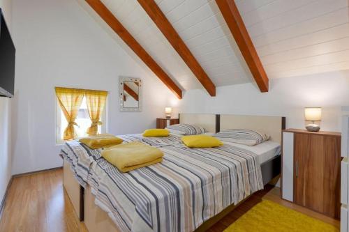 a bedroom with a large bed with yellow pillows at Kuća za odmor Hren in Mursko Središće