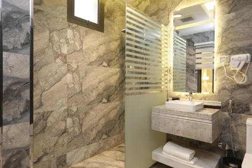 a bathroom with a stone wall and a sink at وايت مون للاجنحة الفندقية الضيافة in Khamis Mushayt