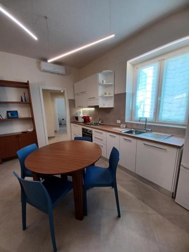 a kitchen with a wooden table and blue chairs at Casa Lerici Holidays in Lerici