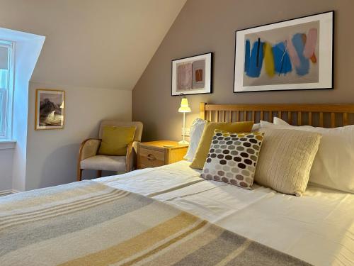 - une chambre avec un grand lit et une chaise dans l'établissement Roskhill House, à Dunvegan