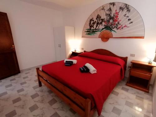 a bedroom with a red bed with two shoes on it at Casa Jack in Chia