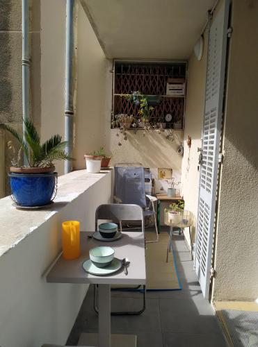 une pièce avec une table et des chaises sur un balcon dans l'établissement PETIT BONHEUR Au COEUR DU VIEUX PORT, à Marseille