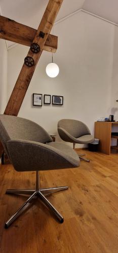 two chairs sitting in a room with wooden floors at Vertshuset Røros in Røros