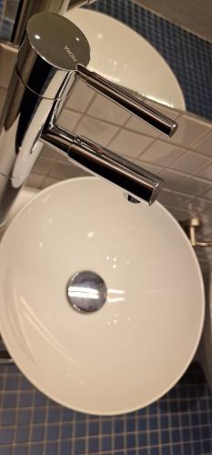 a white toilet with tongs on top of it at Vertshuset Røros in Røros
