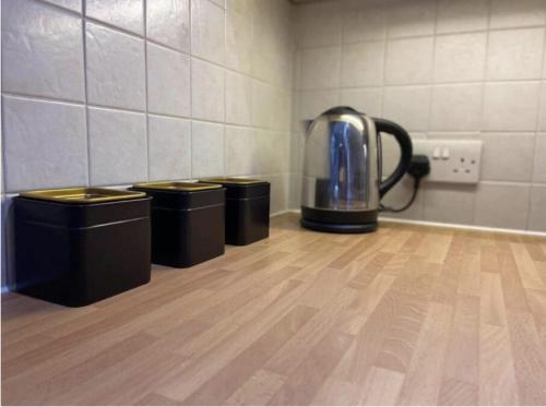 uma chaleira de chá sentada num quarto com três latas de lixo em Luxury Town Centre Apartment em Ipswich