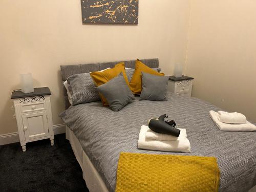 a bedroom with a bed with yellow pillows at Corner House 51 Go Go Street Ground Floor Largs KA308JW 2 Bedroom in Largs