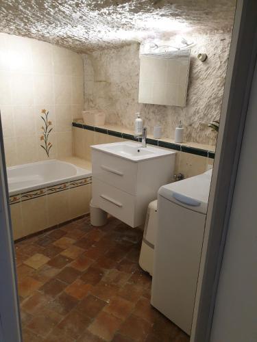 une salle de bain avec un lavabo et une baignoire dans l'établissement Gite troglodyte Les Iris, à Villiers-sur-Loir