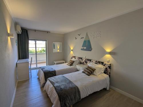a bedroom with two beds and a window at VilaBplaza by JohnVillas in Alvor