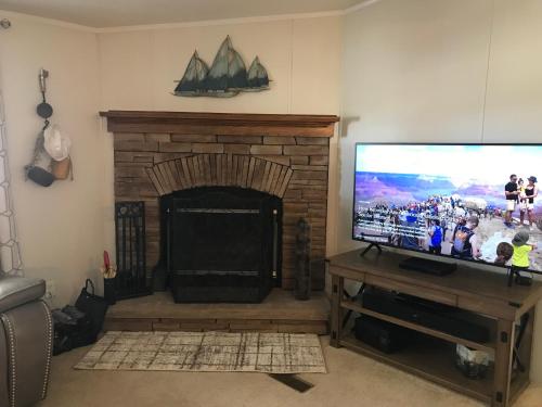 a living room with a fireplace and a flat screen tv at Amazing Views near Grand Canyon Skywalk in Meadview