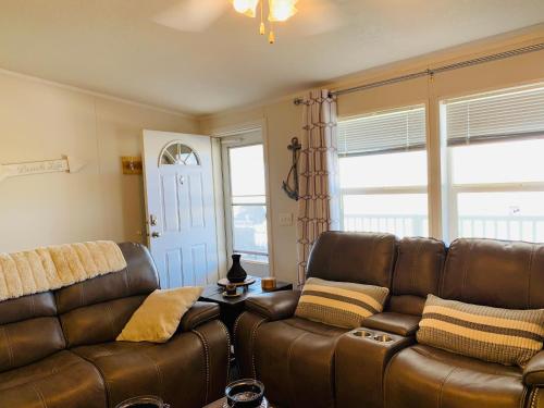 a living room with a leather couch and a table at Amazing Views near Grand Canyon Skywalk in Meadview