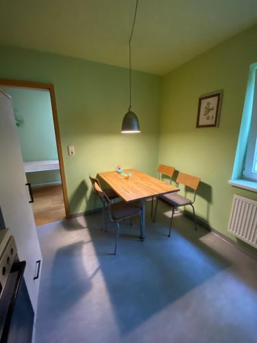 a dining room with a wooden table and chairs at Fewo am Theater mit Terrasse und Stellplatz in Stralsund