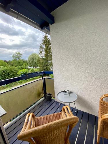 a balcony with two chairs and a table on it at Fewo E am Theater mit Terrasse und Stellplatz in Stralsund