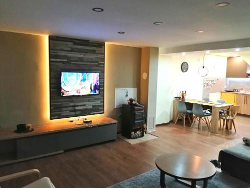a living room with a large flat screen tv on a wall at NIKAS Apartman in Donji Milanovac