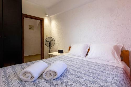a bedroom with a bed with towels on it at The old Phone Center house in Ierápetra