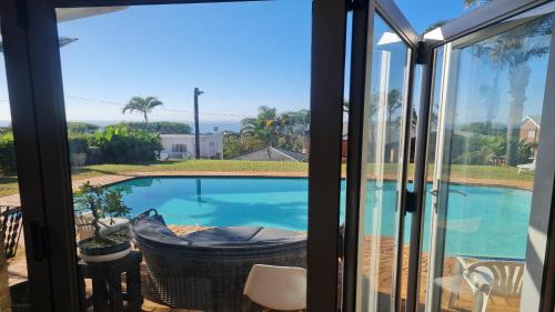 a view from a sliding glass door of a swimming pool at Milk and Honey Guesthouse in Durban