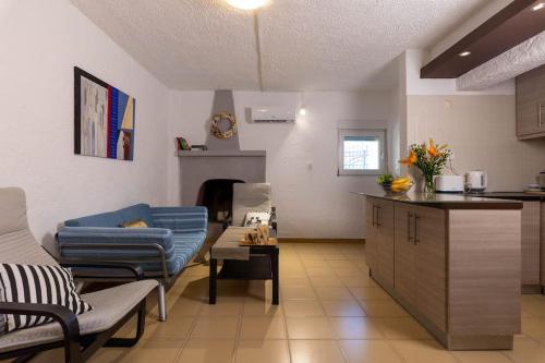 a kitchen and a living room with a blue couch at The old Phone Center house in Ierápetra