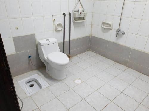 a bathroom with a white toilet in a stall at شقة مفروشة رقم 1 تبعد عن الحرم النبوي الشريف 3 كم in Al Madinah