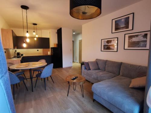salon z kanapą i stołem w obiekcie Apartament Stary Tartak 11 przy ulicy 3Maja 15A w Ostródzie