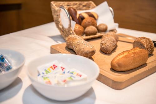 a table with a cutting board with bread and a basket at Hotel Rotes Haus in Brugg