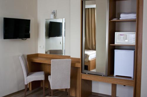 a room with a desk with a mirror and a microwave at Istanbul Central Hotel in Istanbul