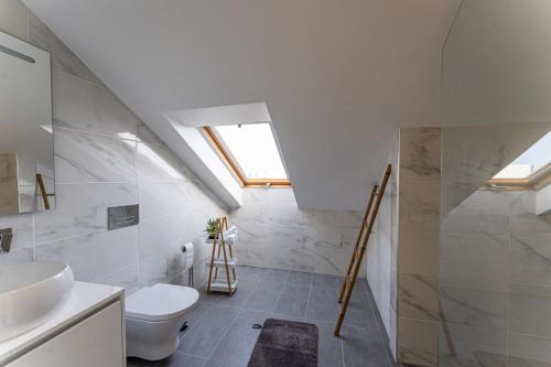 een badkamer met een toilet, een wastafel en een raam bij Penthouse Formosa Sunset and Beach in Funchal
