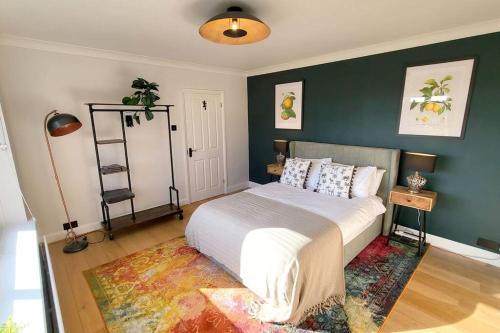 a bedroom with a bed and a green wall at Arundel Castle River House, The Palms in Arundel