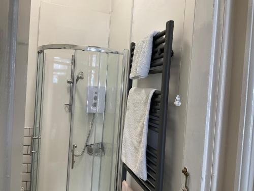 a bathroom with a shower with a mirror and towels at Corner House 51 Go Go Street Ground Floor Largs KA308JW 2 Bedroom in Largs