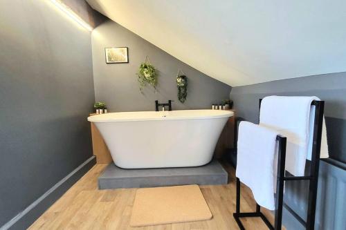 a bathroom with a large white bath tub in a attic at Arundel Castle River House, The Palms in Arundel