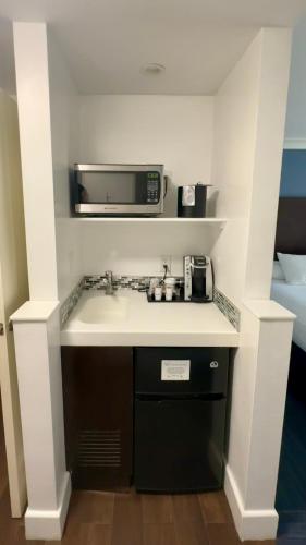 a small kitchen with a sink and a microwave at The Pacific Inn in Seal Beach