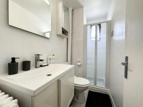 La salle de bains blanche est pourvue de toilettes et d'un lavabo. dans l'établissement A 6 mns de la station de ski Crozet, proche Genève, à Chevry
