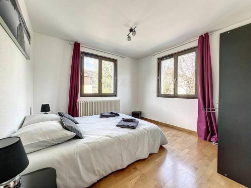 1 dormitorio con 1 cama grande y 2 ventanas en A 6 mns de la station de ski Crozet, proche Genève, en Chevry