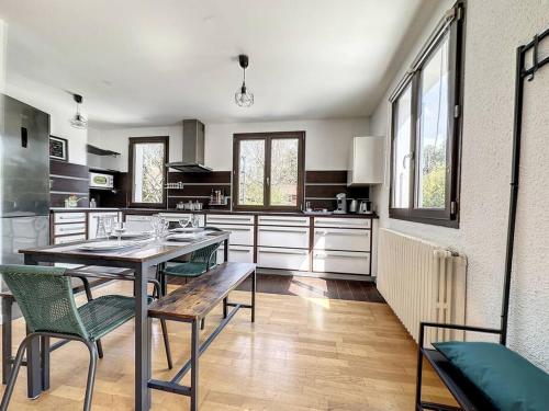 une grande cuisine avec une table et des chaises. dans l'établissement A 6 mns de la station de ski Crozet, proche Genève, à Chevry
