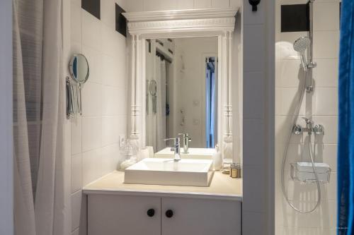 a white bathroom with a sink and a shower at La Martinoise Studio in Saint-Martin-de-Ré
