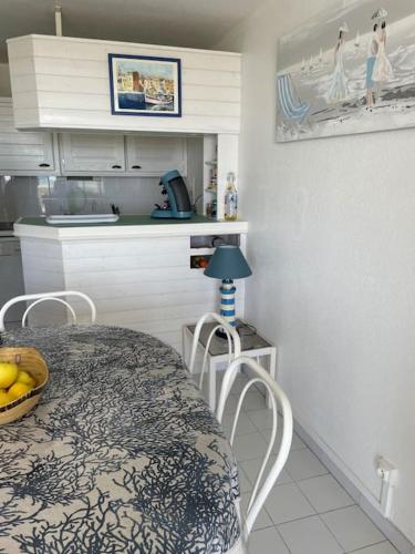 une cuisine avec une table et des chaises dans une pièce dans l'établissement Port Leucate : superbe appartement pleine vue mer, à Leucate