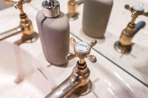 a bathroom sink with a faucet with a soap bottle at Stylish 1 Bedroom apartment in Edinburgh