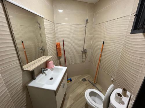 La salle de bains est pourvue d'un lavabo, de toilettes et d'un miroir. dans l'établissement Appartement Relax Saidia, à Saïdia